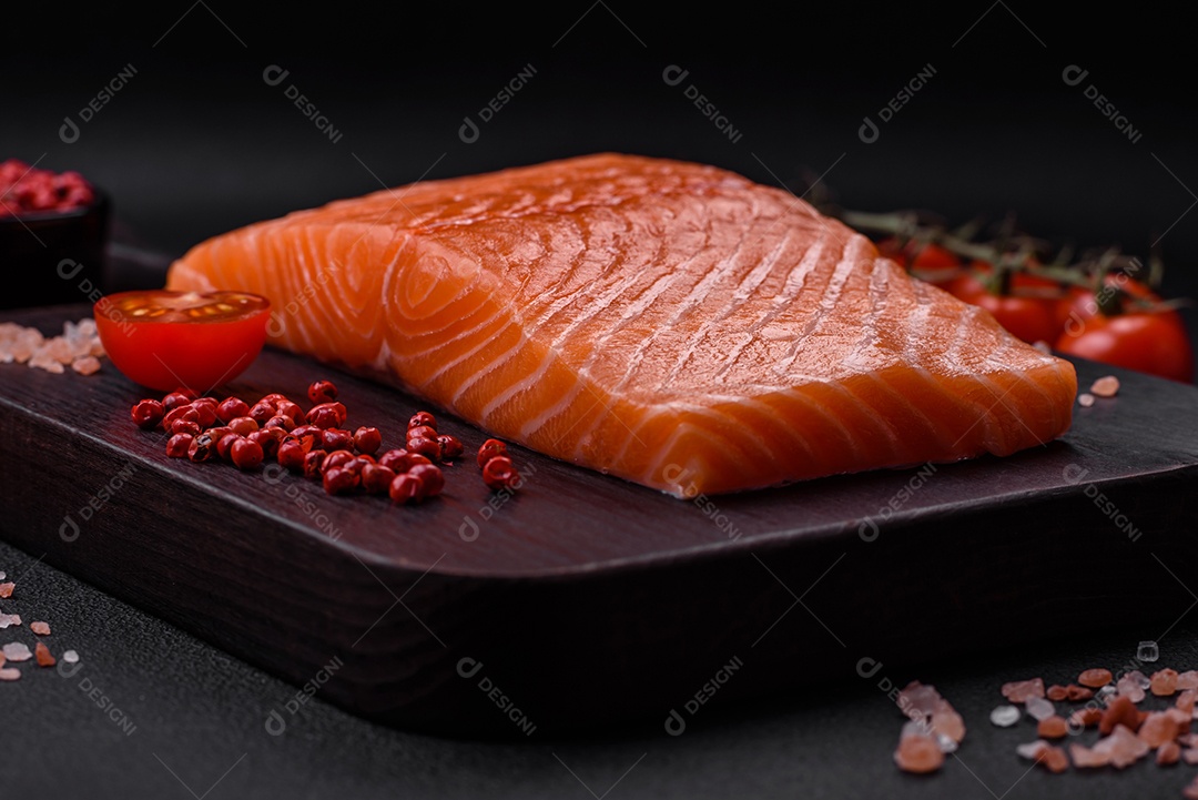 Filé de peixe vermelho salmão cru fresco com sal e especiarias sobre um fundo escuro de concreto