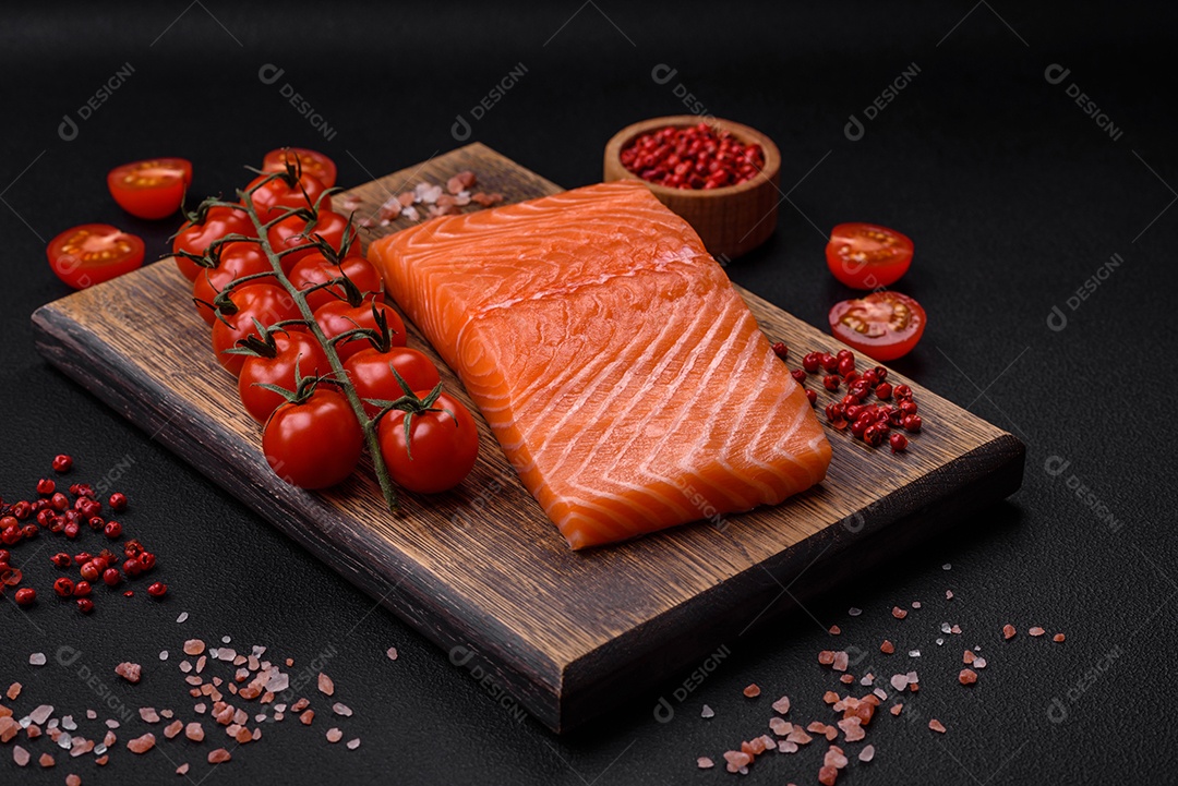 Filé de peixe vermelho salmão cru fresco com sal e especiarias sobre um fundo escuro de concreto