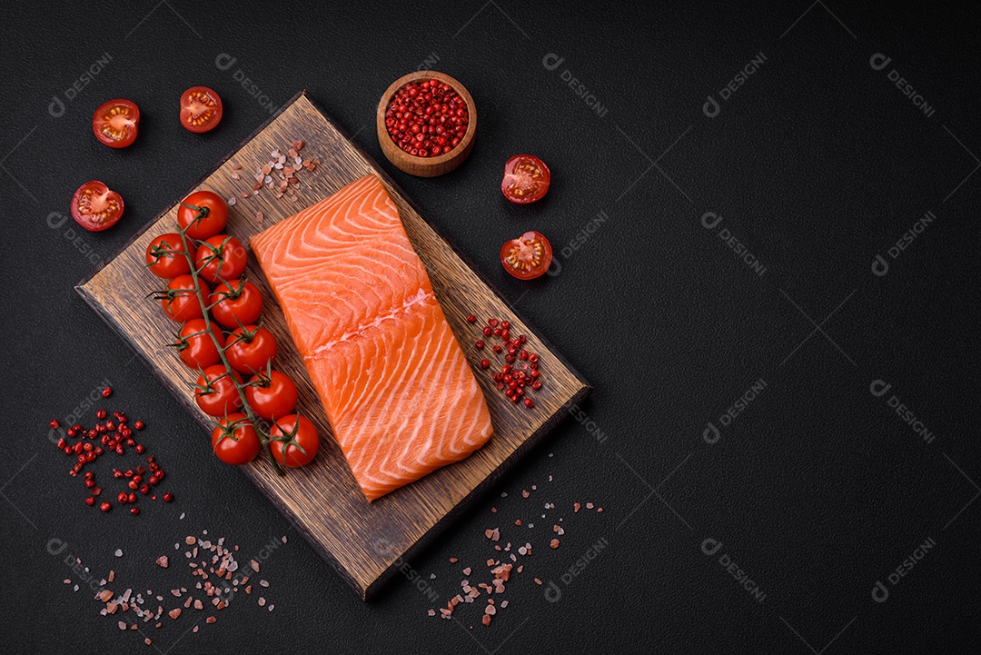 Filé de peixe vermelho salmão cru fresco com sal e especiarias sobre um fundo escuro de concreto