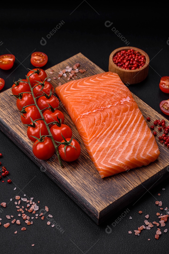 Filé de peixe vermelho salmão cru fresco com sal e especiarias sobre um fundo escuro de concreto