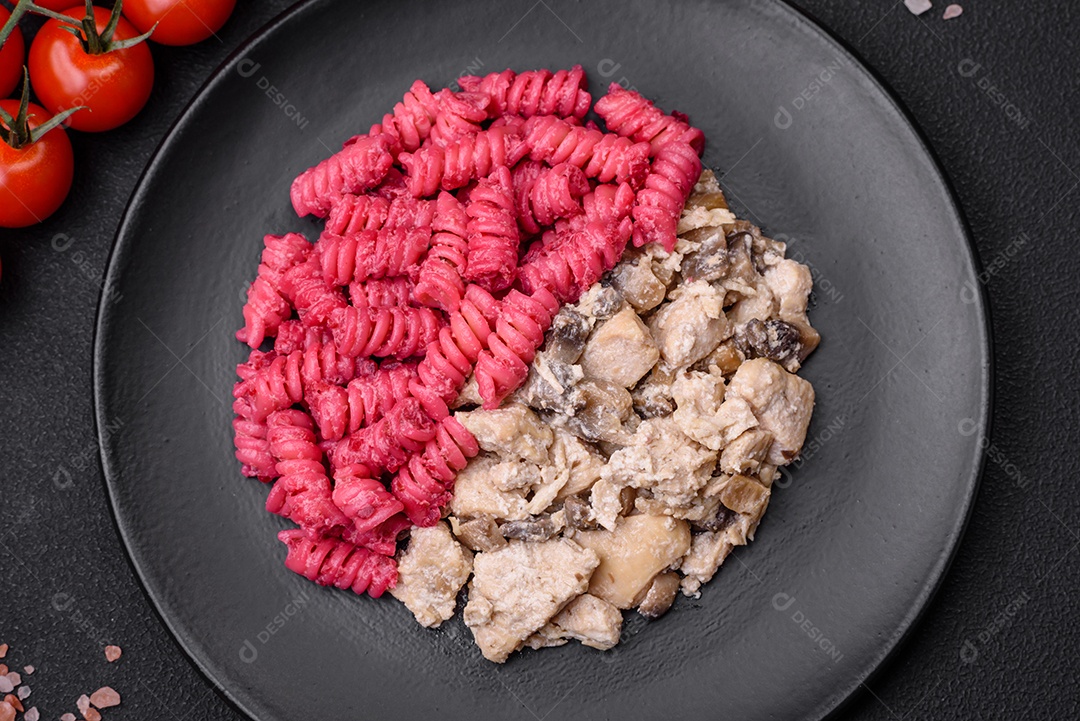 Deliciosa massa fusilli com pesto de beterraba, parmesão, sal e especiarias sobre um fundo escuro de concreto