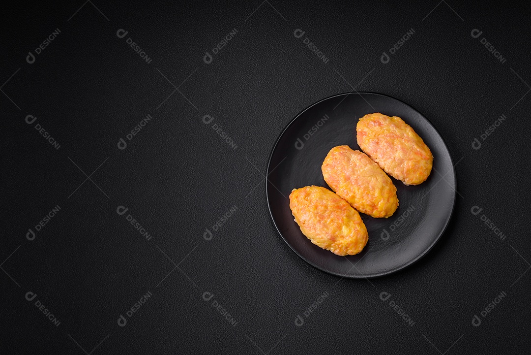 Deliciosas costeletas de vapor com cenoura, queijo, sal e especiarias sobre um fundo escuro de concreto