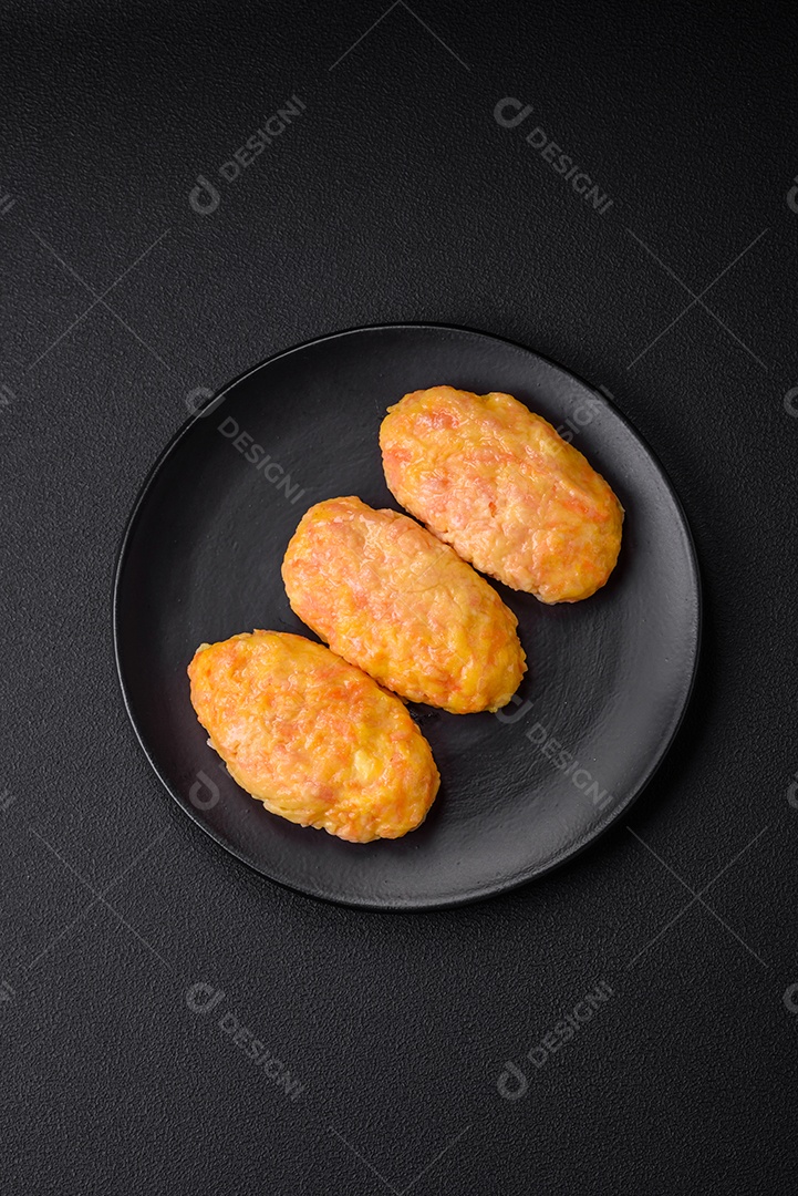 Deliciosas costeletas de vapor com cenoura, queijo, sal e especiarias sobre um fundo escuro de concreto