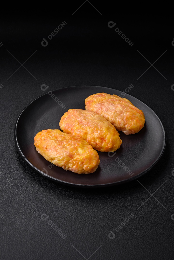 Deliciosas costeletas de vapor com cenoura, queijo, sal e especiarias sobre um fundo escuro de concreto