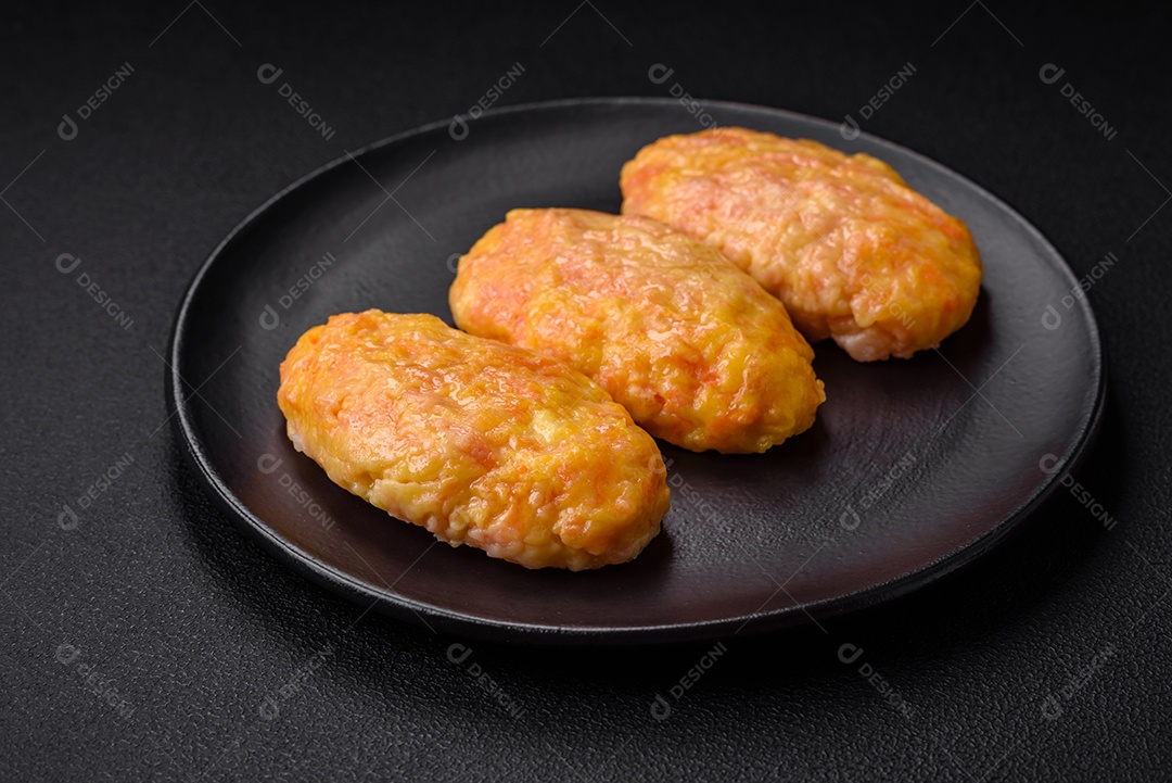 Deliciosas costeletas de vapor com cenoura, queijo, sal e especiarias sobre um fundo escuro de concreto