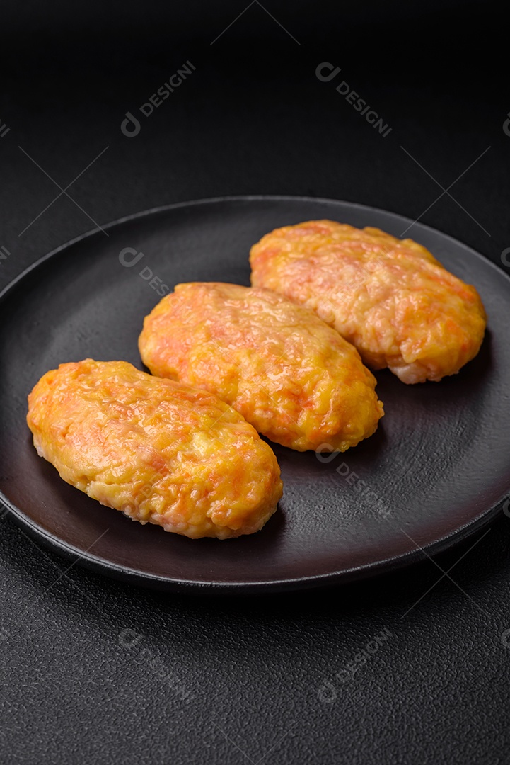 Deliciosas costeletas de vapor com cenoura, queijo, sal e especiarias sobre um fundo escuro de concreto