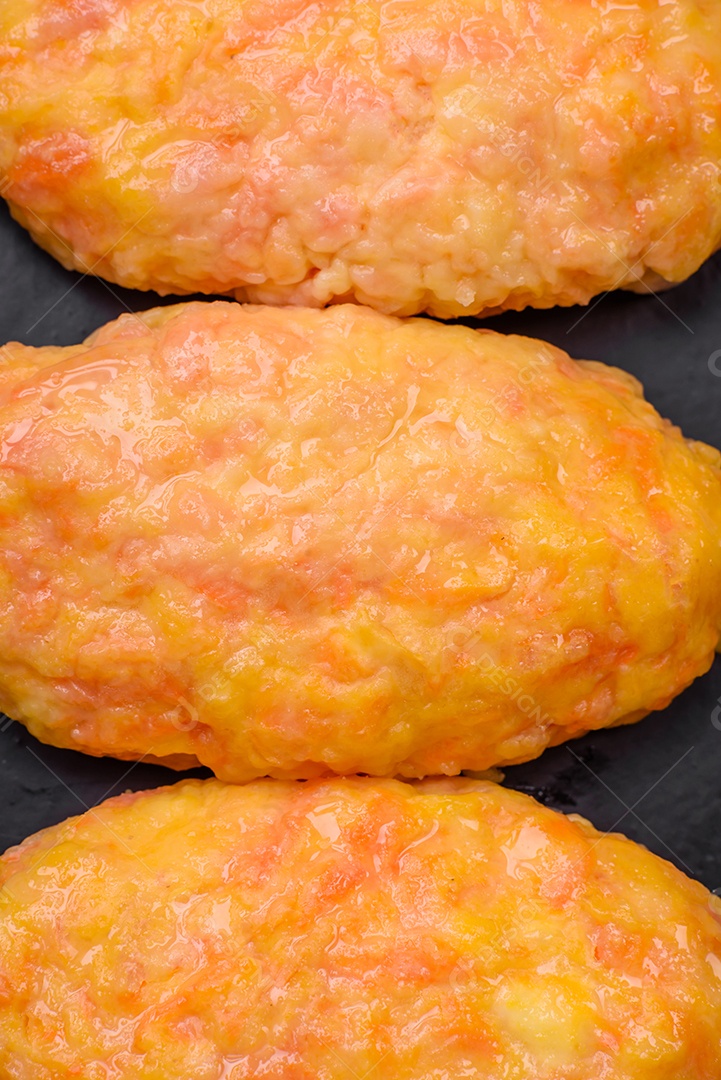 Deliciosas costeletas de vapor com cenoura, queijo, sal e especiarias sobre um fundo escuro de concreto