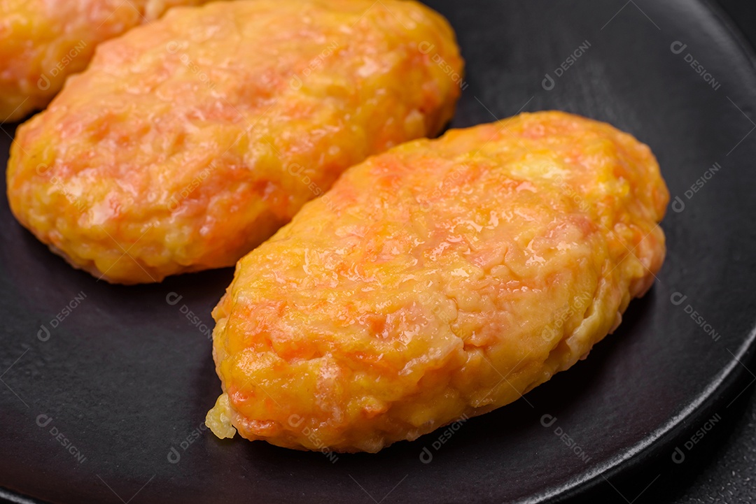 Deliciosas costeletas de vapor com cenoura, queijo, sal e especiarias sobre um fundo escuro de concreto