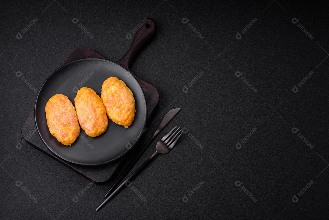 Deliciosas costeletas de vapor com cenoura, queijo, sal e especiarias sobre um fundo escuro de concreto