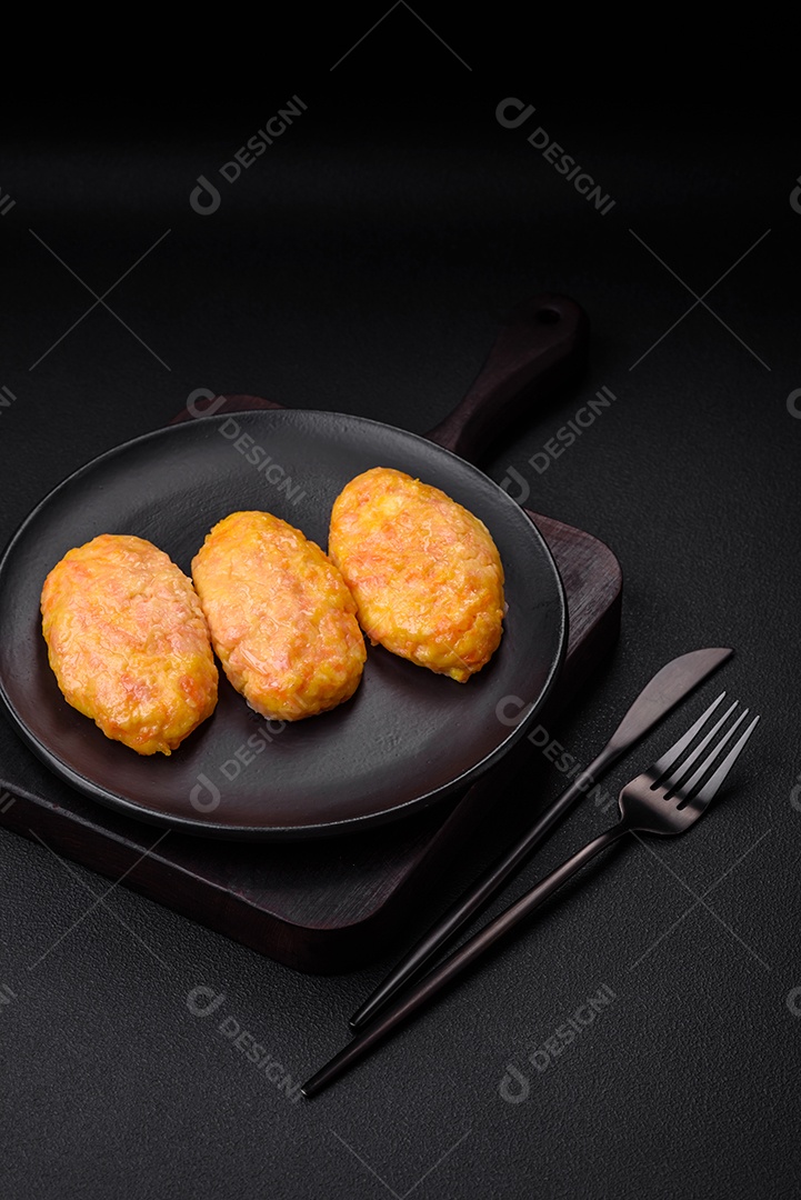 Deliciosas costeletas de vapor com cenoura, queijo, sal e especiarias sobre um fundo escuro de concreto