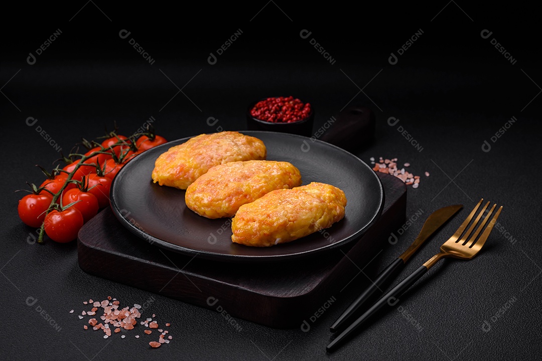 Deliciosas costeletas de vapor com cenoura, queijo, sal e especiarias sobre um fundo escuro de concreto