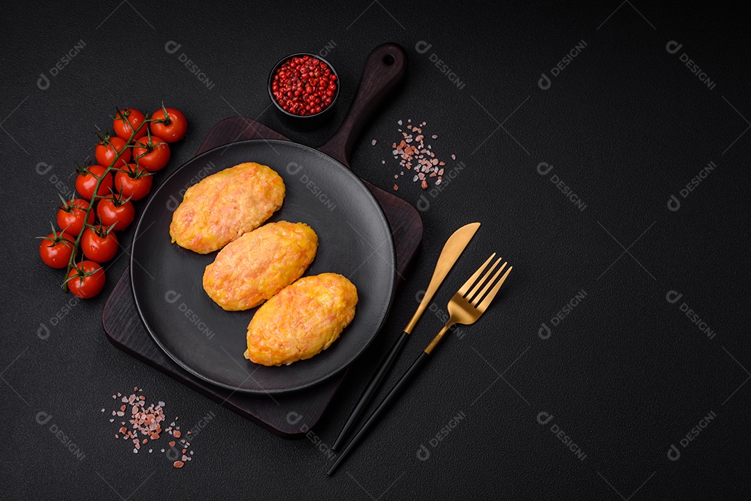 Deliciosas costeletas de vapor com cenoura, queijo, sal e especiarias sobre um fundo escuro de concreto