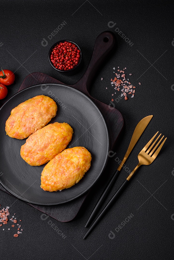 Deliciosas costeletas de vapor com cenoura, queijo, sal e especiarias sobre um fundo escuro de concreto