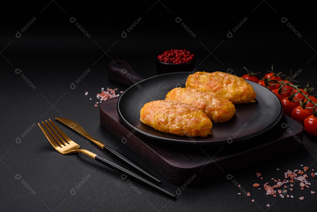 Deliciosas costeletas de vapor com cenoura, queijo, sal e especiarias sobre um fundo escuro de concreto
