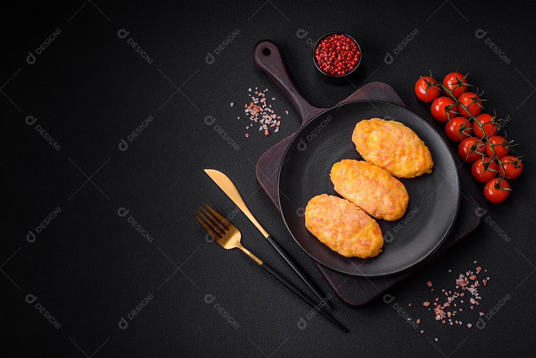 Deliciosas costeletas de vapor com cenoura, queijo, sal e especiarias sobre um fundo escuro de concreto