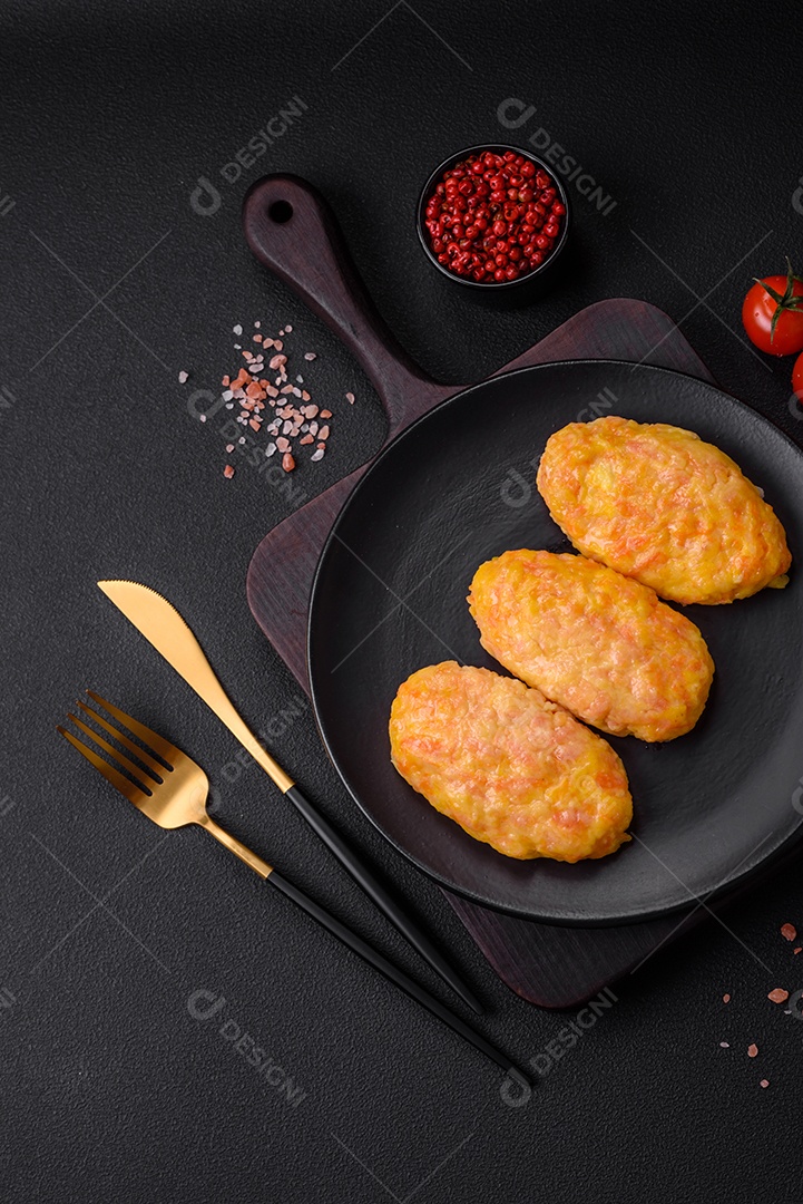 Deliciosas costeletas de vapor com cenoura, queijo, sal e especiarias sobre um fundo escuro de concreto