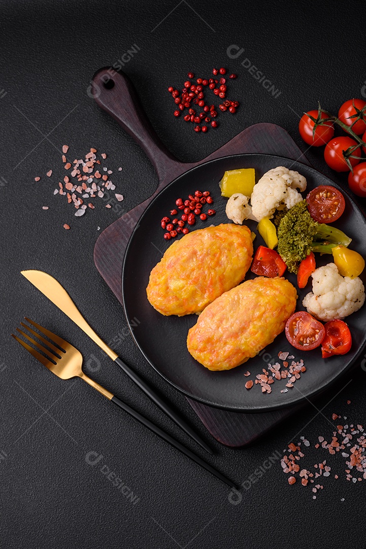 Deliciosas costeletas de vapor com cenoura, queijo, sal e especiarias sobre um fundo escuro de concreto