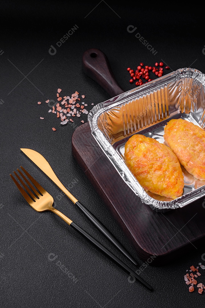 Deliciosas costeletas de vapor com cenoura, queijo, sal e especiarias sobre um fundo escuro de concreto