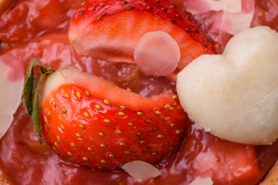 Deliciosas tortinhas doces frescas com morangos e flocos de coco sobre um fundo escuro de concreto