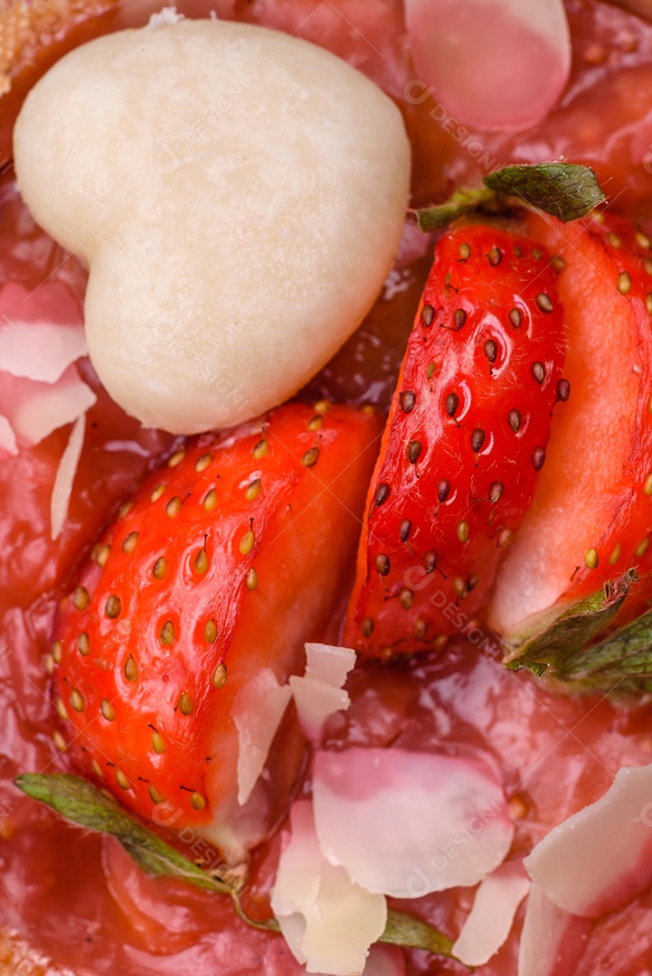 Deliciosas tortinhas doces frescas com morangos e flocos de coco sobre um fundo escuro de concreto