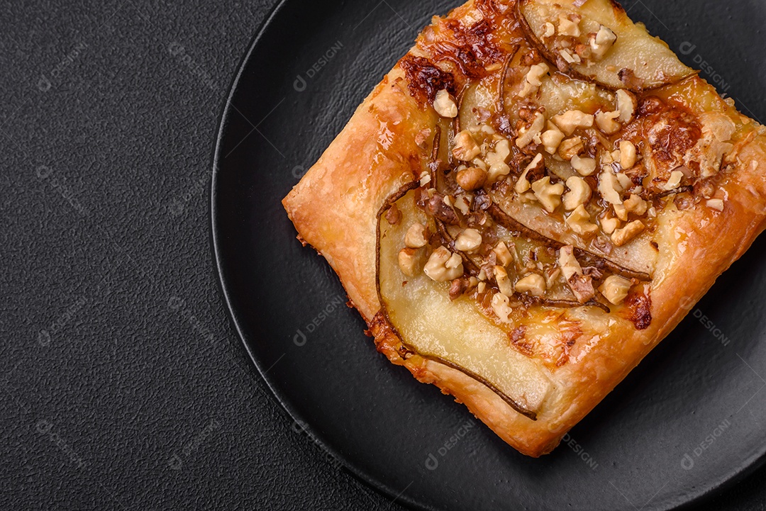 Deliciosa torta doce fresca ou pizza com pera, queijo brie, mel e nozes sobre um fundo escuro de concreto