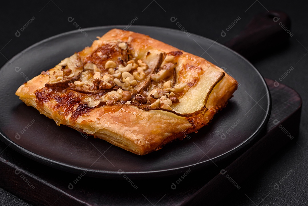 Deliciosa torta doce fresca ou pizza com pera, queijo brie, mel e nozes sobre um fundo escuro de concreto