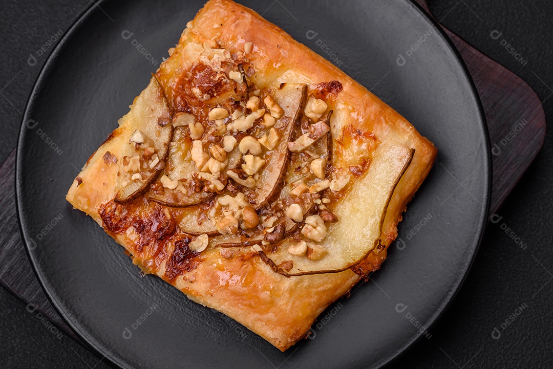 Deliciosa torta doce fresca ou pizza com pera, queijo brie, mel e nozes sobre um fundo escuro de concreto