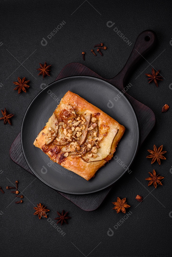 Deliciosa torta doce fresca ou pizza com pera, queijo brie, mel e nozes sobre um fundo escuro de concreto