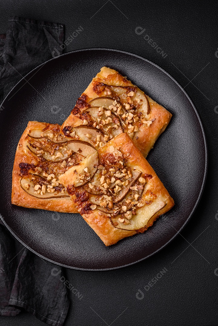 Deliciosa torta doce fresca ou pizza com pera, queijo brie, mel e nozes sobre um fundo escuro de concreto
