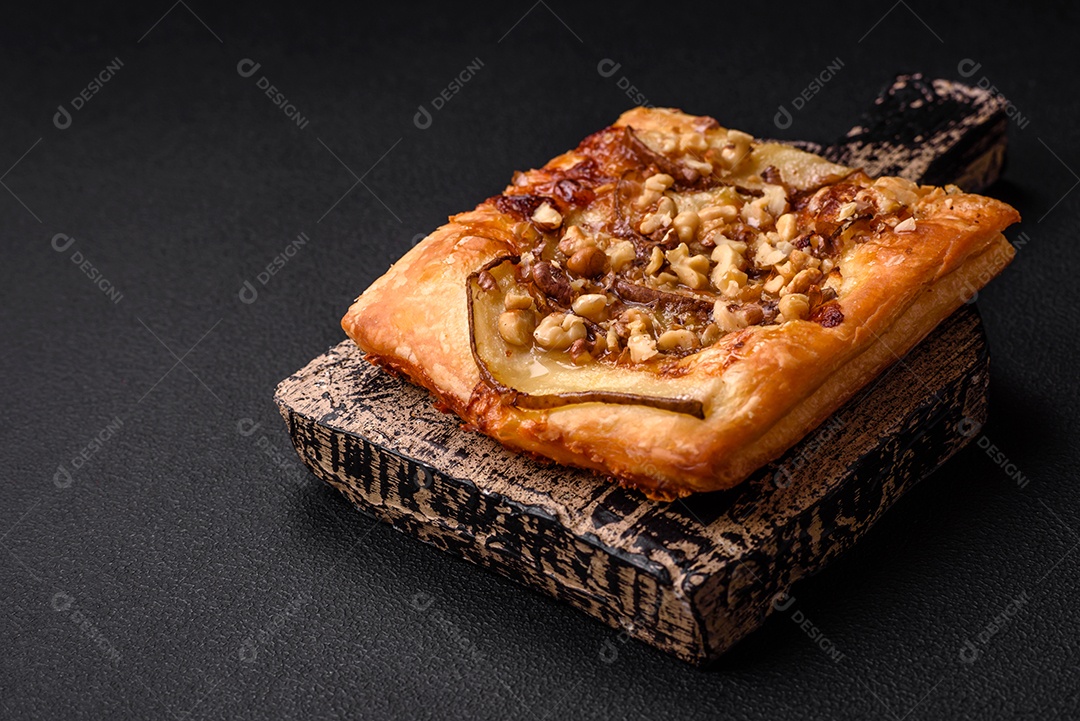 Deliciosa torta doce fresca ou pizza com pera, queijo brie, mel e nozes sobre um fundo escuro de concreto