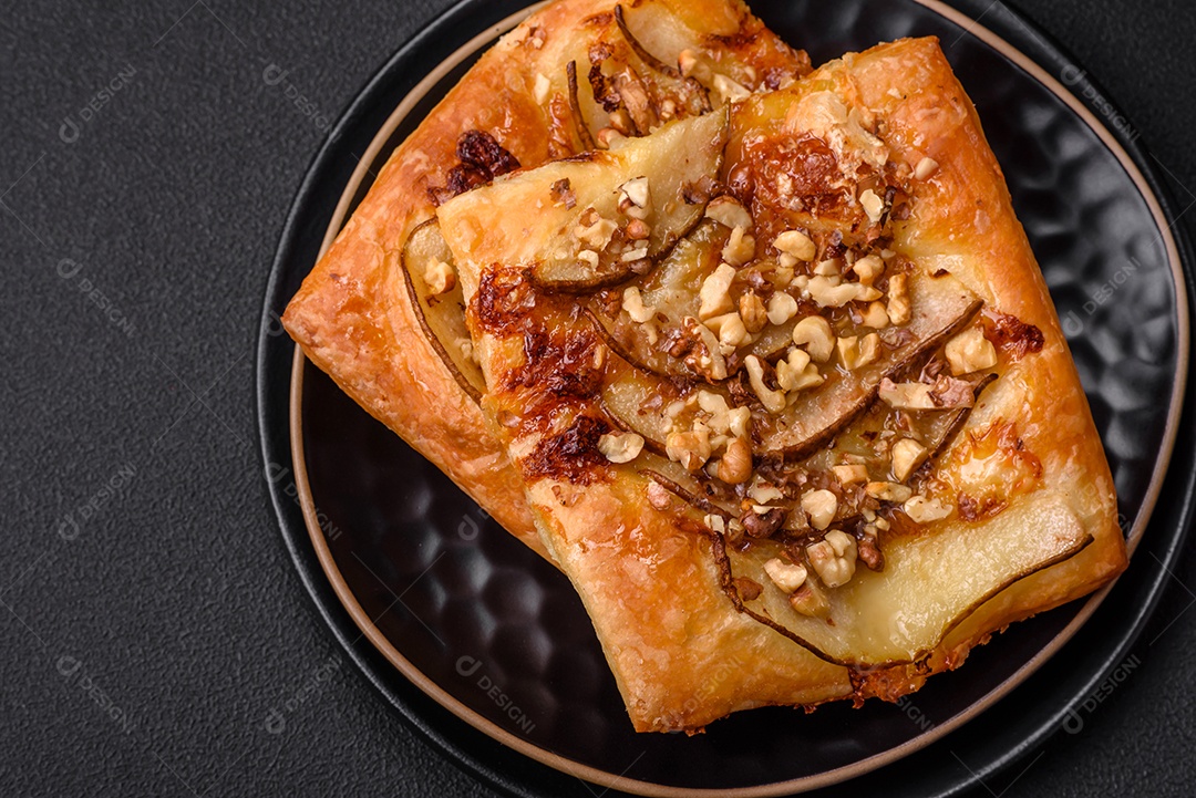 Deliciosa torta doce fresca ou pizza com pera, queijo brie, mel e nozes sobre um fundo escuro de concreto
