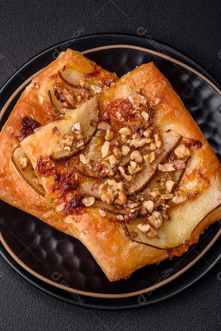 Deliciosa torta doce fresca ou pizza com pera, queijo brie, mel e nozes sobre um fundo escuro de concreto