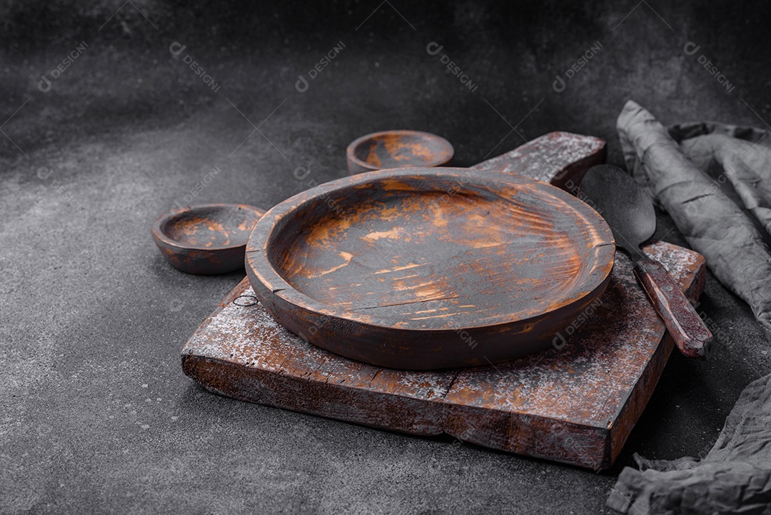 Prato de madeira vazio, faca, garfo e tábua de corte em fundo de concreto texturizado