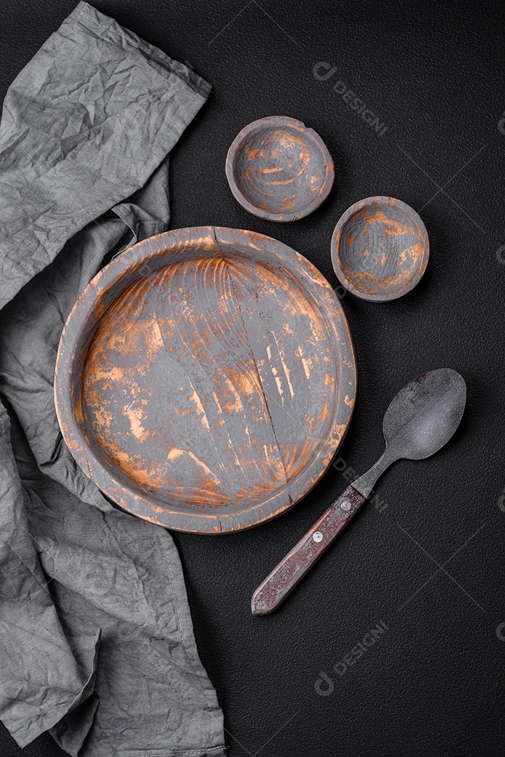 Prato de madeira vazio, faca, garfo e tábua de corte em fundo de concreto texturizado