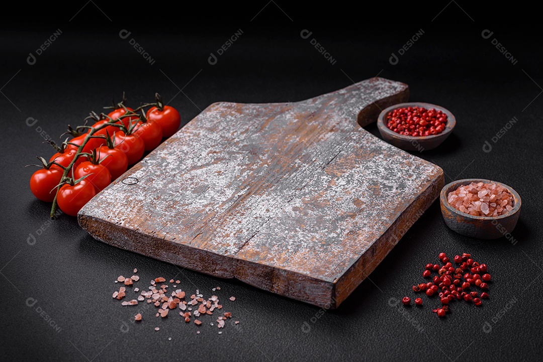 Faca garfo e tábua sal pimenta e outros ingredientes localizados em um fundo de concreto texturizado