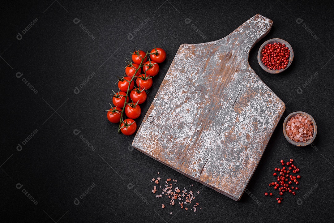 Faca garfo e tábua sal pimenta e outros ingredientes localizados em um fundo de concreto texturizado