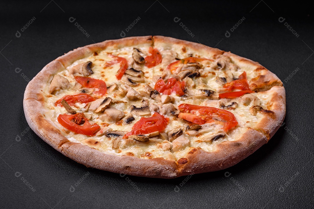 Deliciosa pizza com frango, tomate e queijo com sal e molho sobre um fundo escuro de concreto