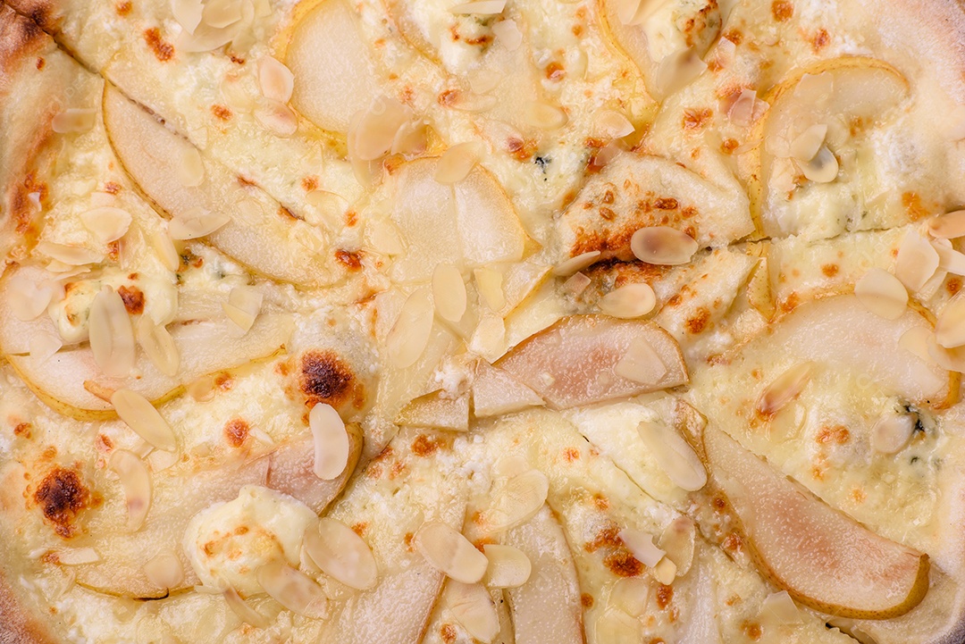 Pizza bávara com enchidos, tomates, queijo, sal e especiarias sobre um fundo escuro de concreto