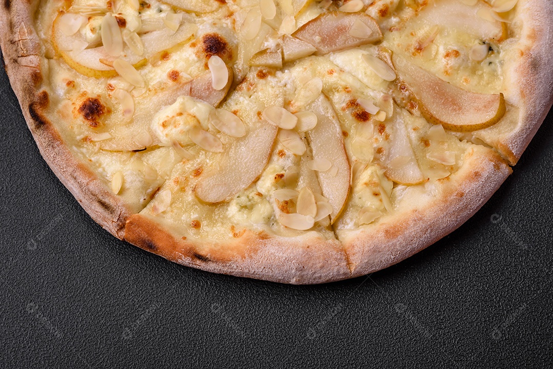 Pizza bávara com enchidos, tomates, queijo, sal e especiarias sobre um fundo escuro de concreto