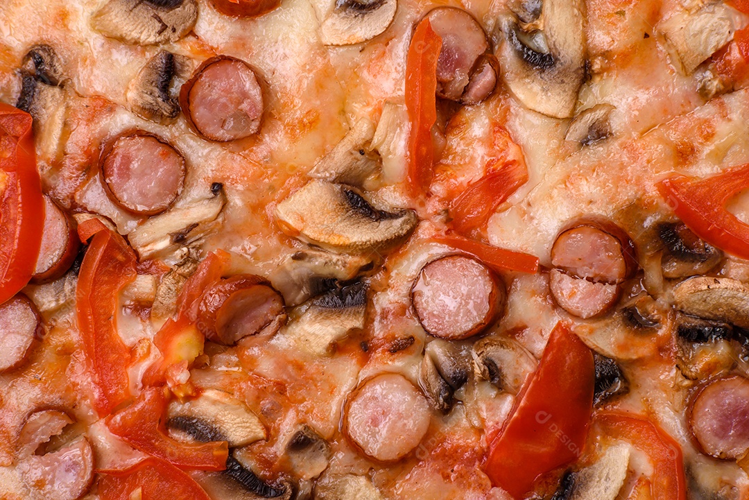 Pizza bávara com enchidos, tomates, queijo, sal e especiarias sobre um fundo escuro de concreto