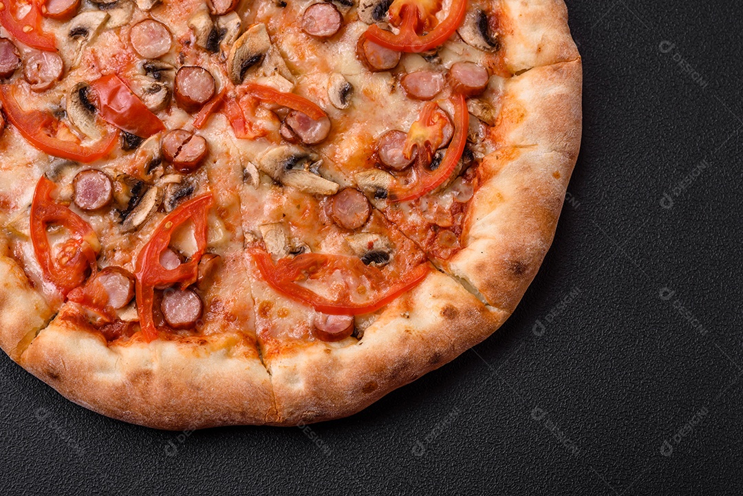 Pizza bávara com enchidos, tomates, queijo, sal e especiarias sobre um fundo escuro de concreto