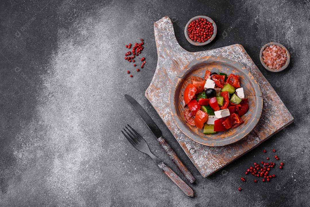 Nozes torradas e nozes de macadâmia, tangerina seca, frutos secos sobre um fundo escuro de concreto