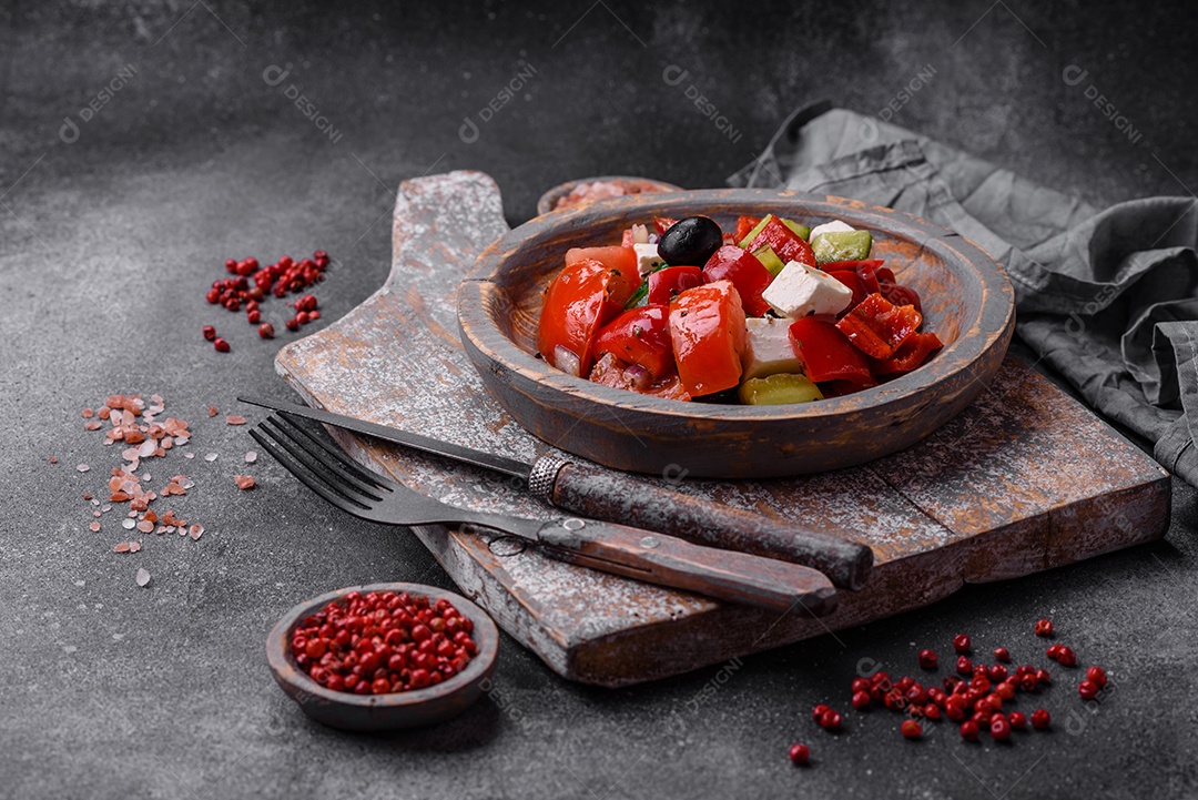 Nozes torradas e nozes de macadâmia, tangerina seca, frutos secos sobre um fundo escuro de concreto