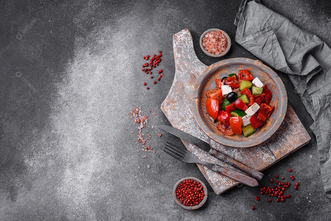 Nozes torradas e nozes de macadâmia, tangerina seca, frutos secos sobre um fundo escuro de concreto