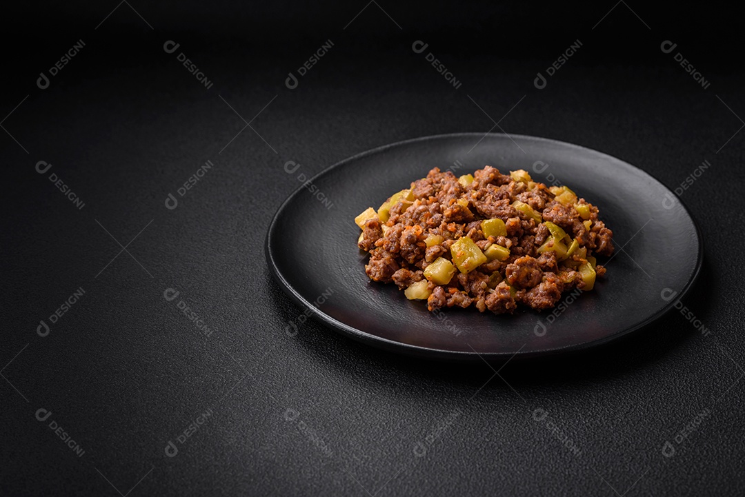 Saboroso prato composto por abobrinha, carne bovina, cogumelos, cebola e alho com sal e especiarias sobre um fundo escuro de concreto