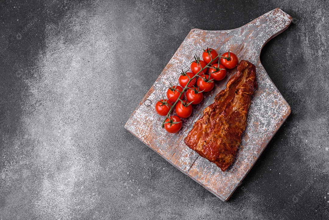 Deliciosas costelas de porco grelhadas ou defumadas com sal, especiarias e ervas em fundo de concreto texturizado