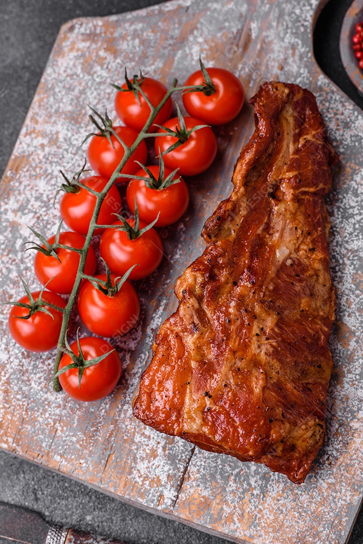 Deliciosas costelas de porco grelhadas ou defumadas com sal, especiarias e ervas em fundo de concreto texturizado