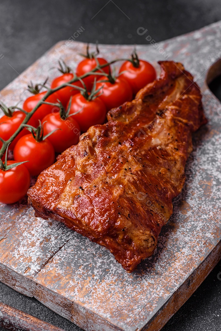 Deliciosas costelas de porco grelhadas ou defumadas com sal, especiarias e ervas em fundo de concreto texturizado