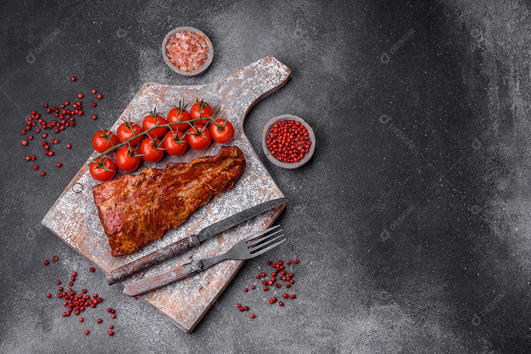 Deliciosas costelas de porco grelhadas ou defumadas com sal, especiarias e ervas em fundo de concreto texturizado