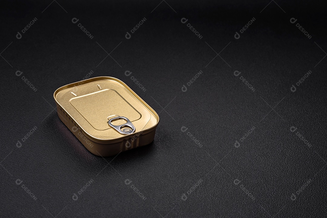 Lata retangular de estanho ou alumínio de alimentos enlatados com uma chave sobre um fundo escuro de concreto